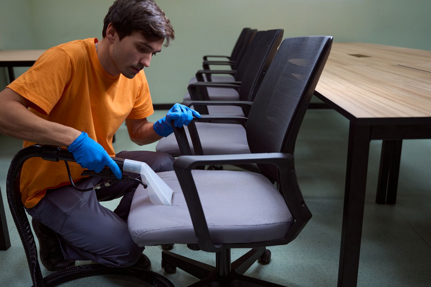 man deep cleaning office chairs